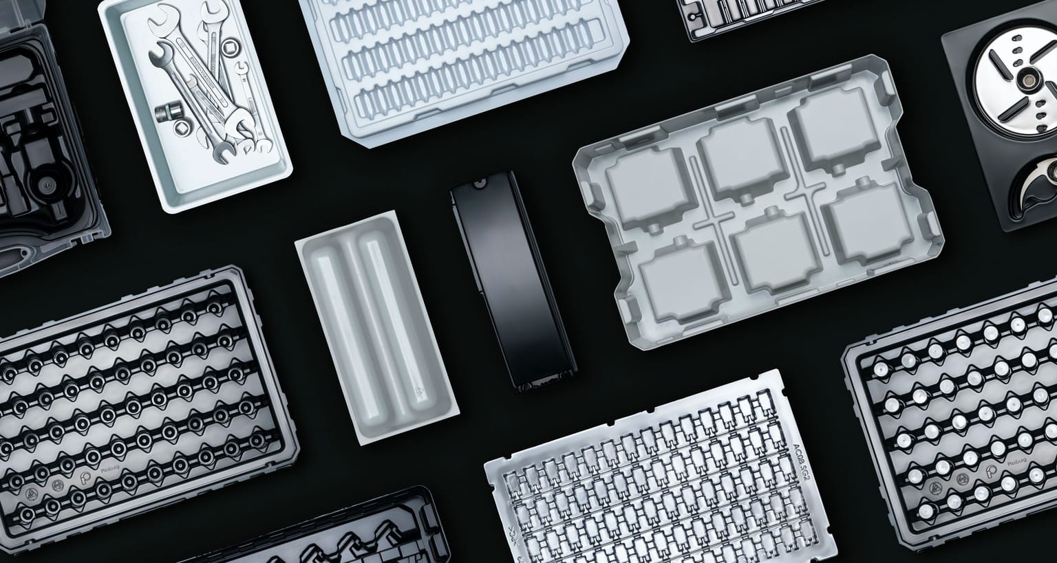 Tiefziehteile in verschiedenen Variationen vor einem schwarzen Hintergrund